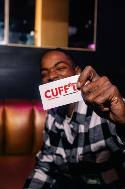 Attendee holding a Cuff'd card at the event